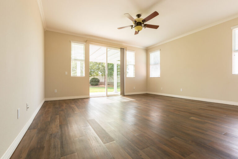 Interior room with wood floors and windows, illustrating home ownership advice.