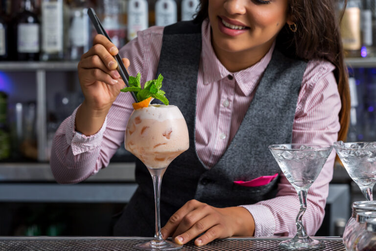 Bartender decorating cocktail illustrating career opportunities and professional development.