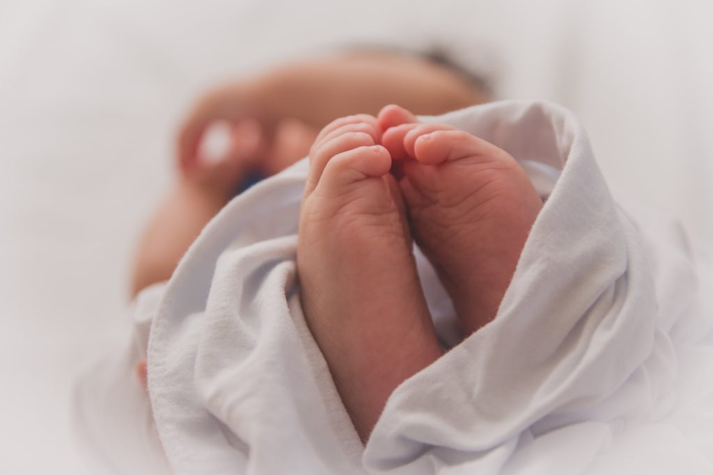 a baby's feet in a white shirt