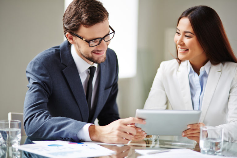 a man and a woman looking at a tablet