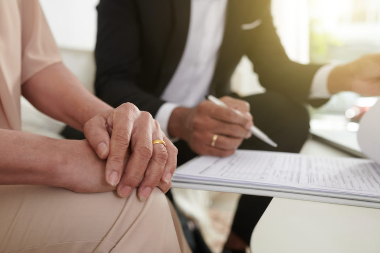 a close-up of a person signing a document