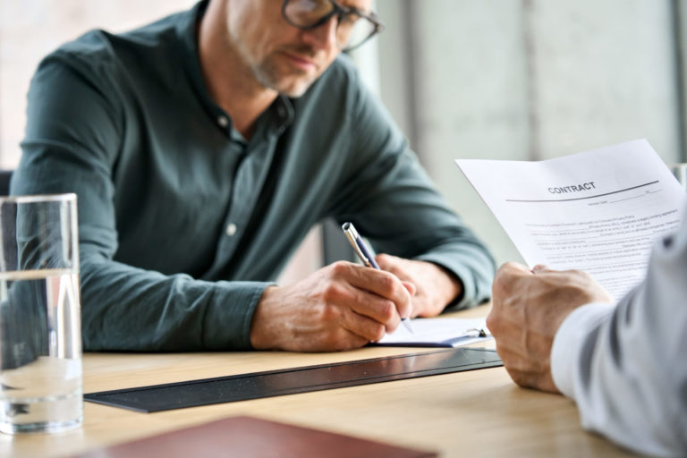 a man writing on a piece of paper