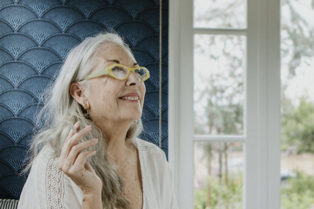 a person with glasses looking out a window