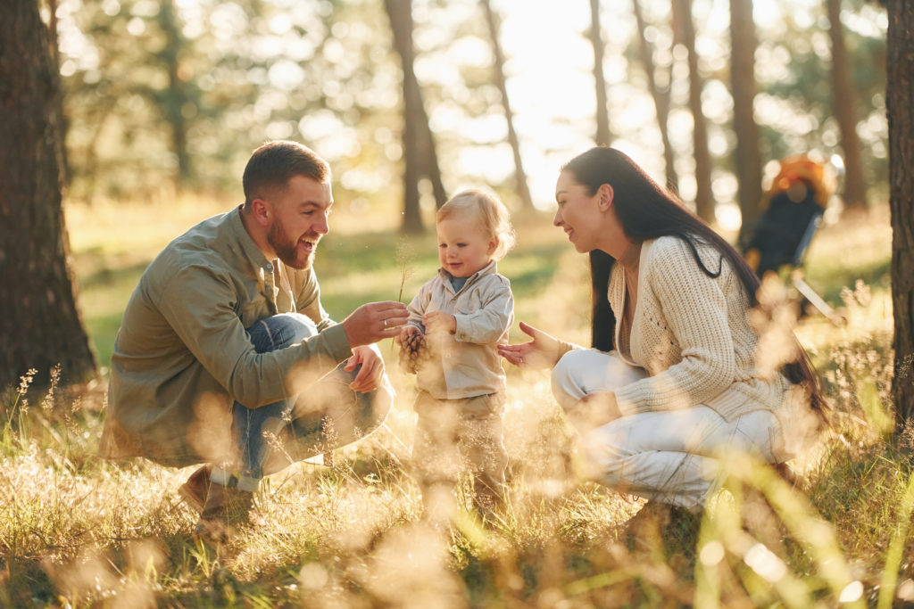 Having fun. Happy family of father, mother and little daughter is in the forest