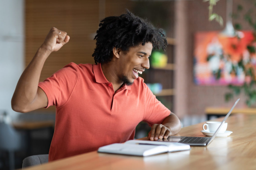 Good News. Emotional Black Man Looking At Laptop Screen And Celenbrating Success